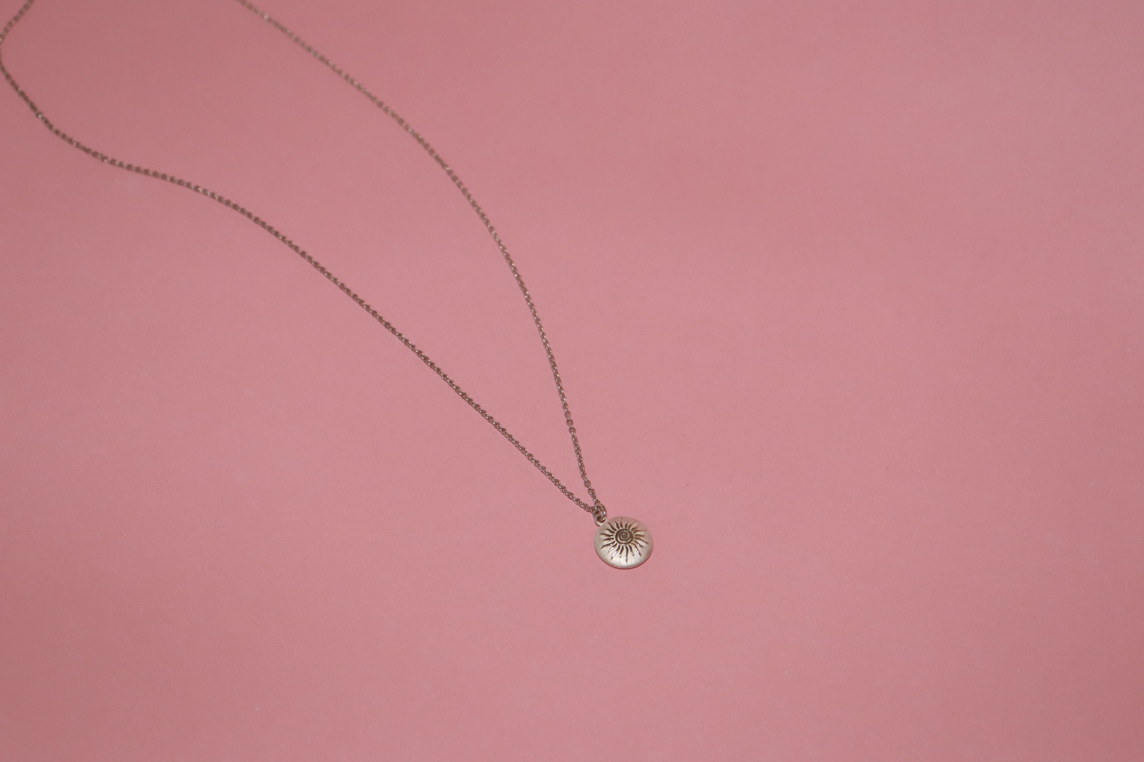 Silver necklace with sun design