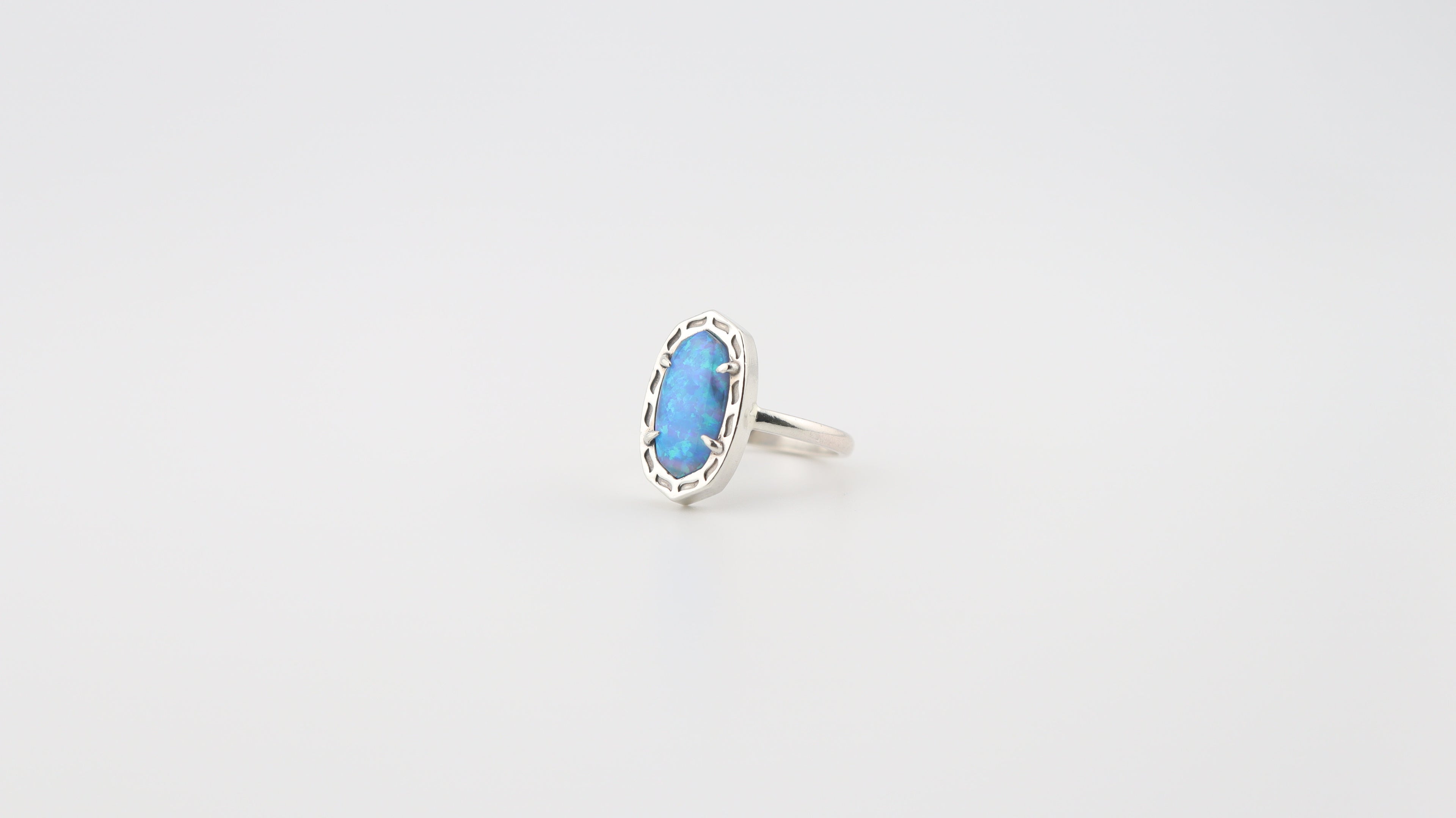 Silver ring with a blue gemstone on a light gray background
