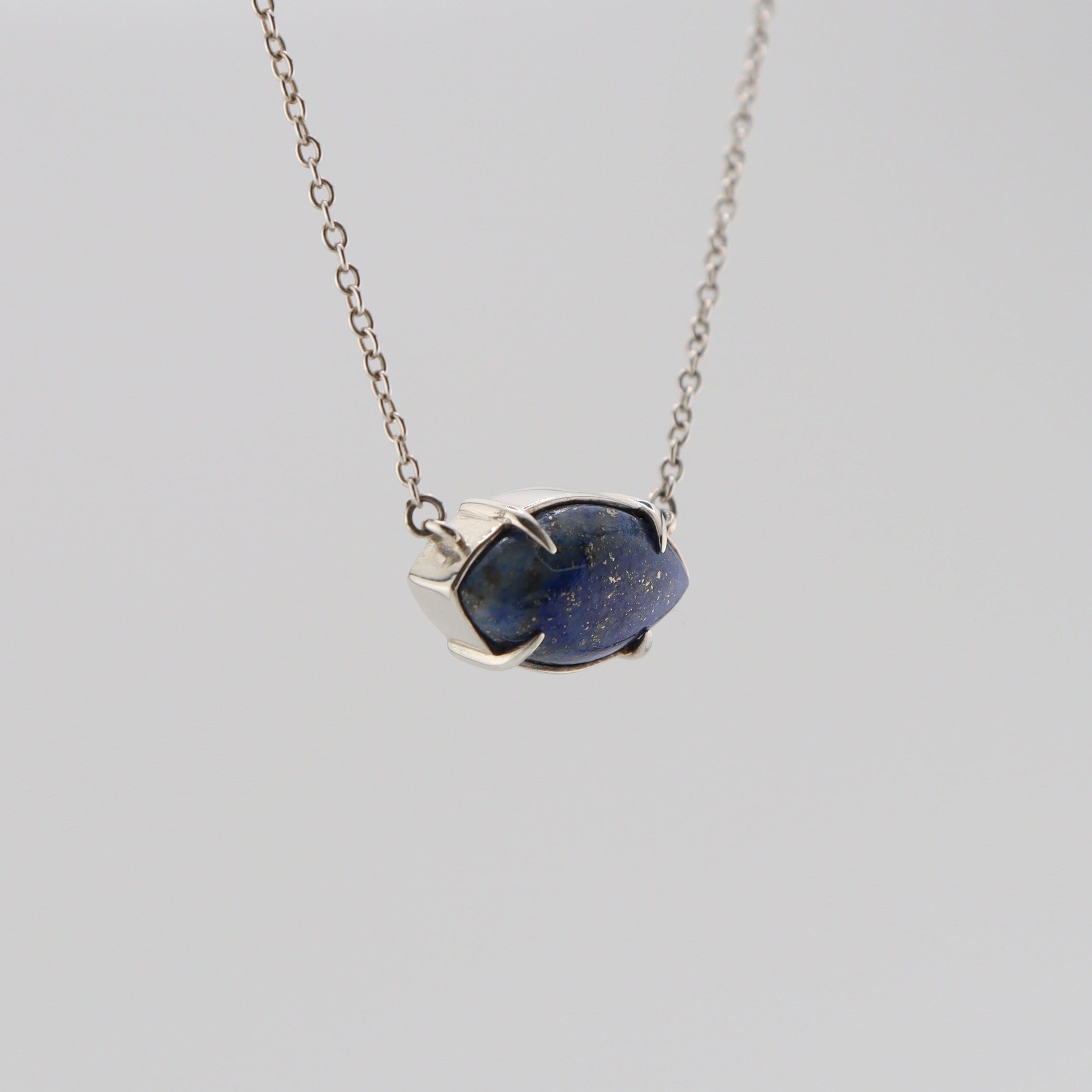 Silver necklace with lapis lazuli set in a marquise pendant on a white background