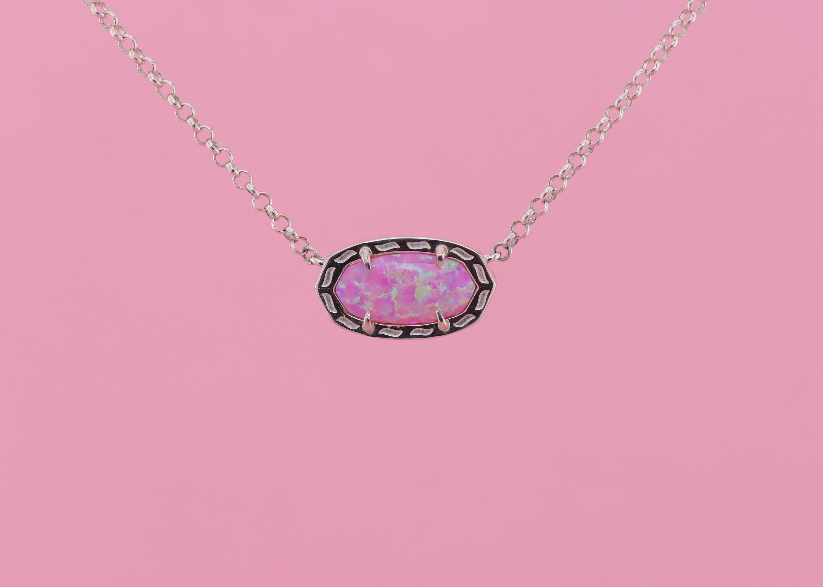 Necklace with a pink stone set in pendant on a pink background