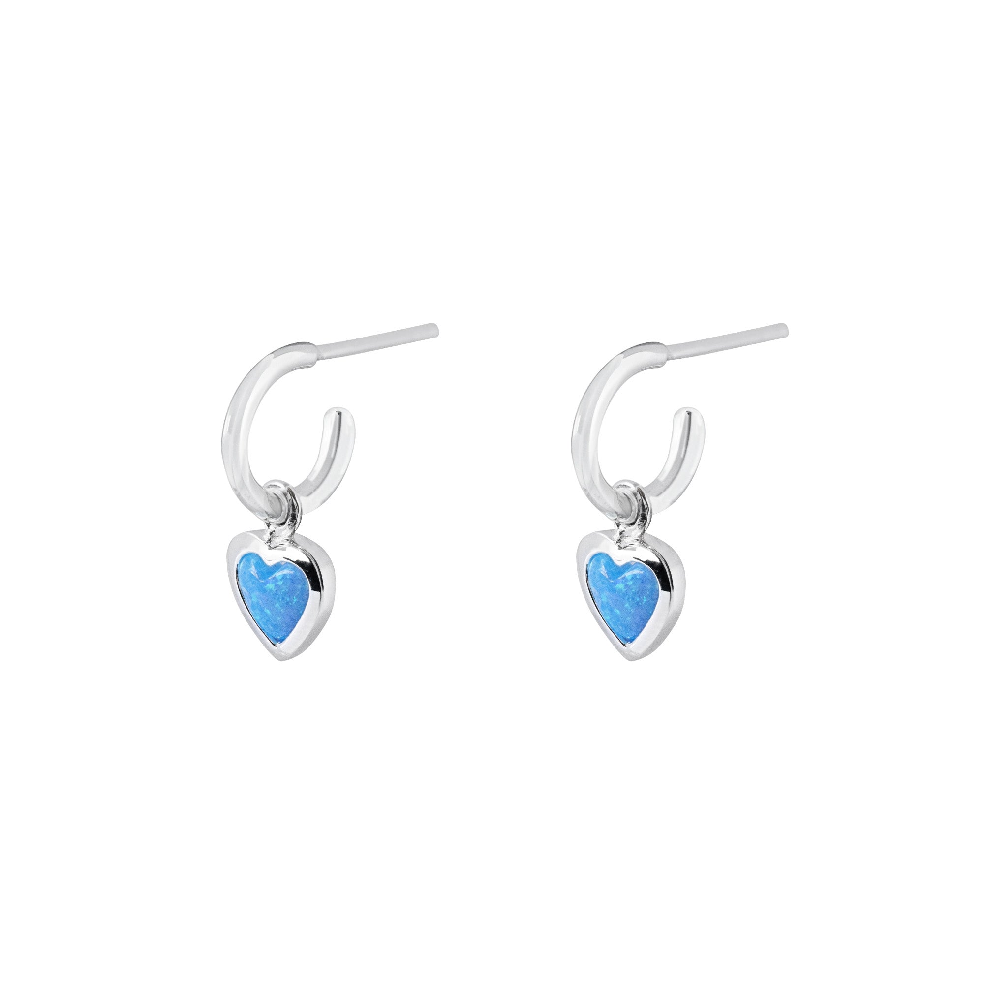 Silver hoop earrings with heart-shaped charms with blue heart stones on a white background
