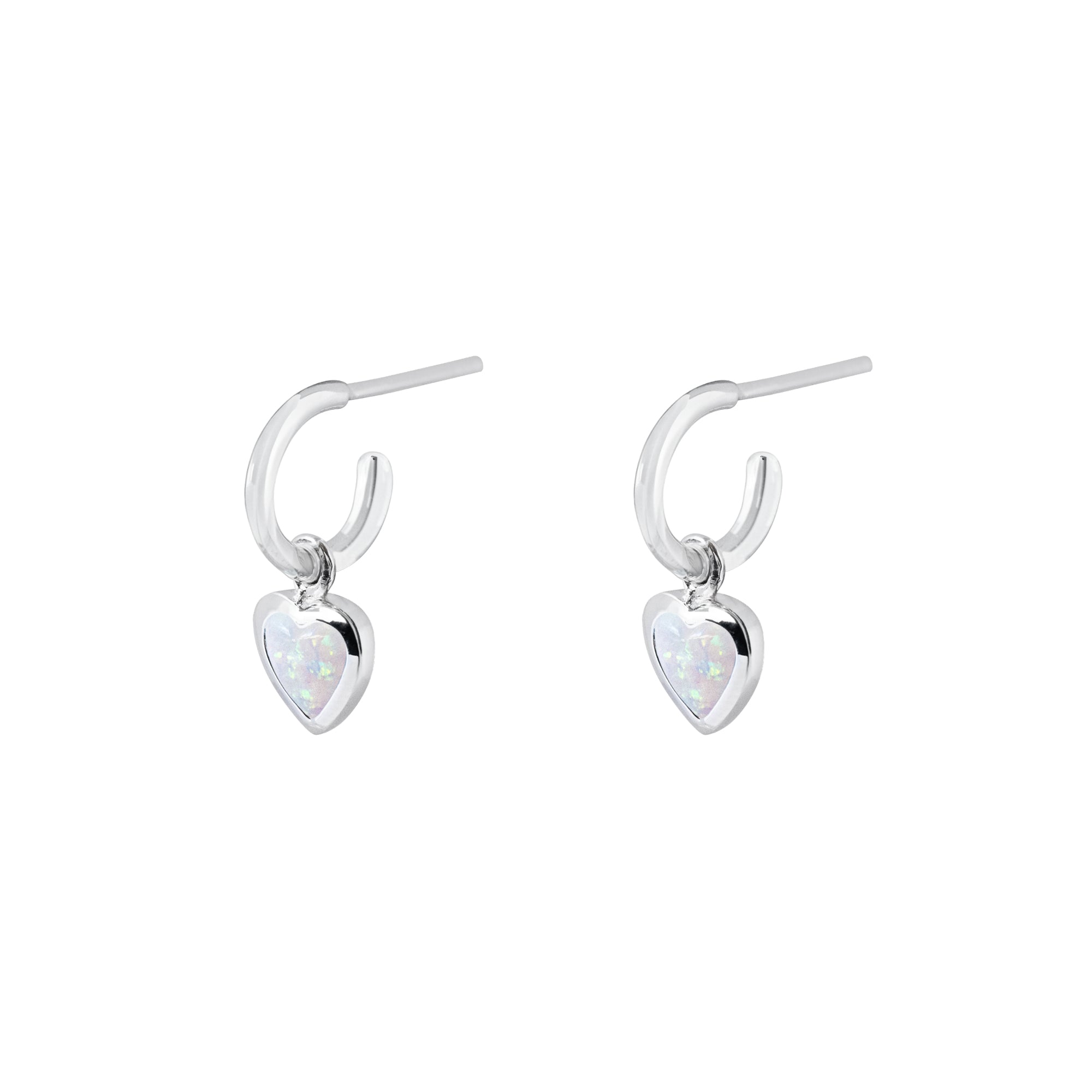 Silver hoop earrings with heart-shaped charms with white heart stones on a white background
